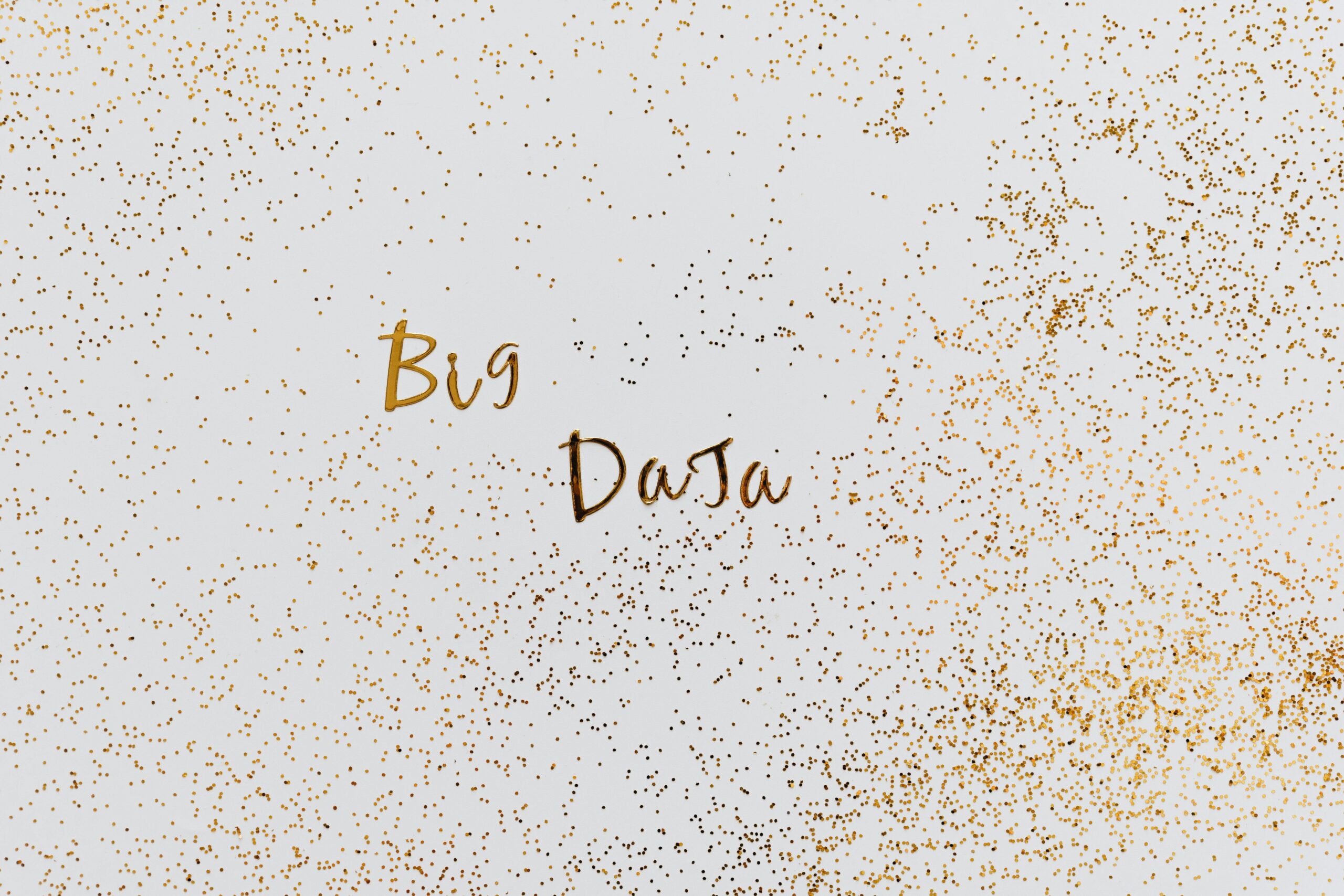 Creative representation of big data with gold particles on white background.